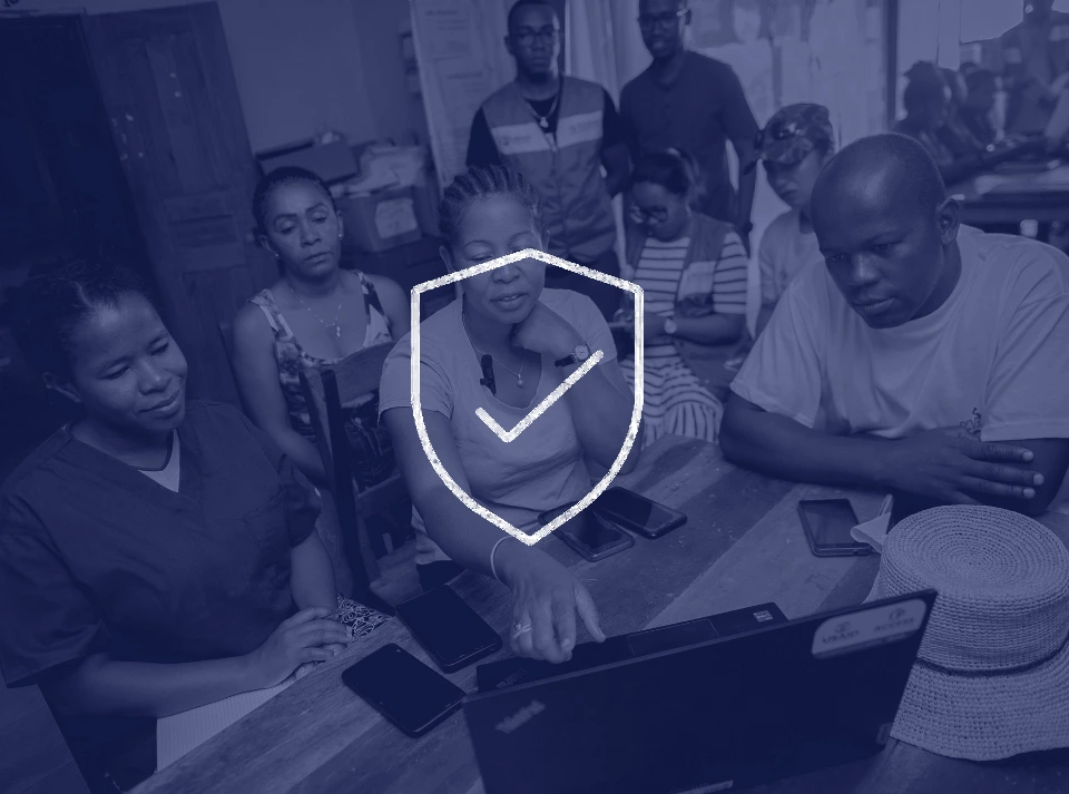 A health program team reviewing CommCare data together on a laptop