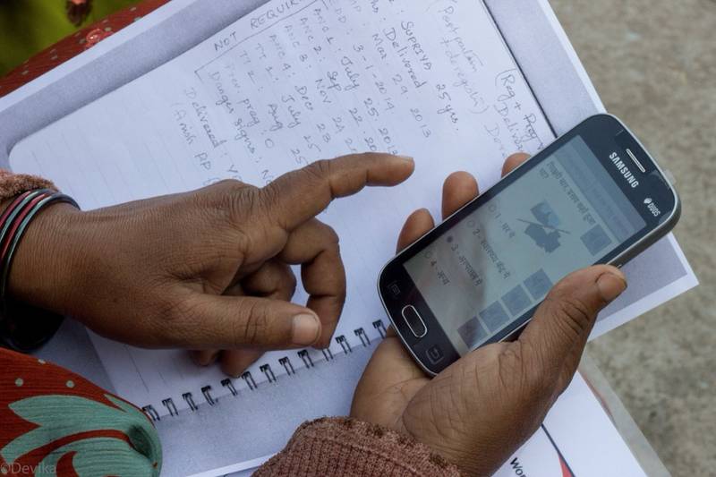 Frontline health worker using a mobile device to collect data in the field