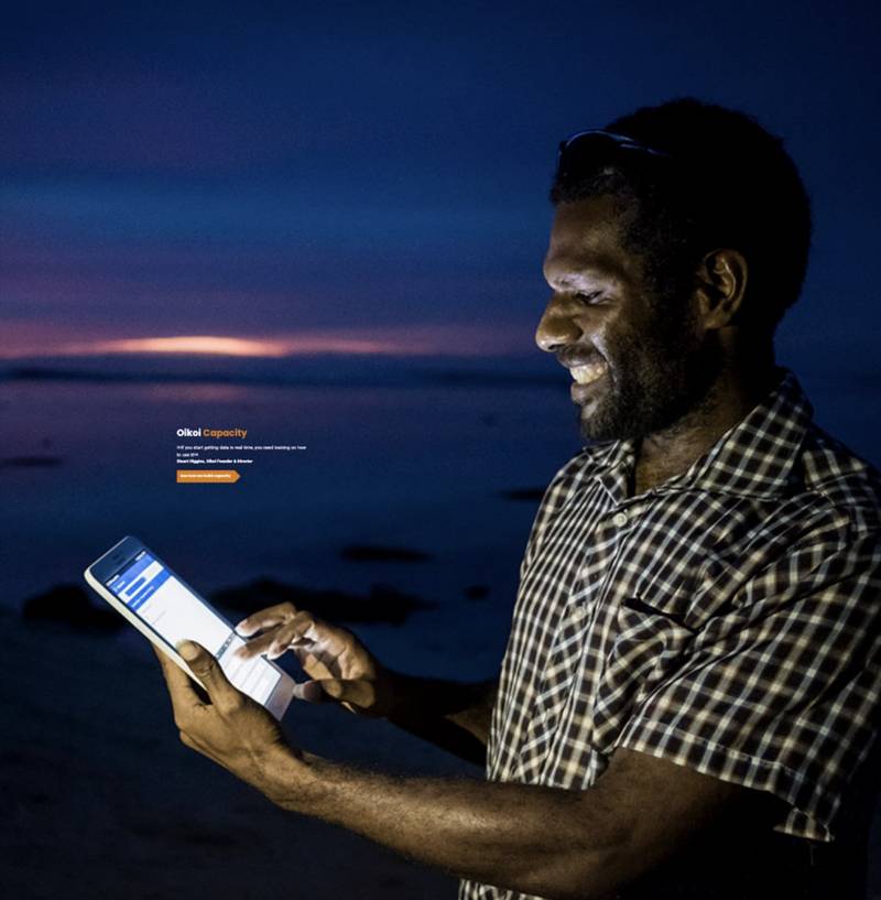 A CommCare Provider using the platform on a tablet in the field at dusk