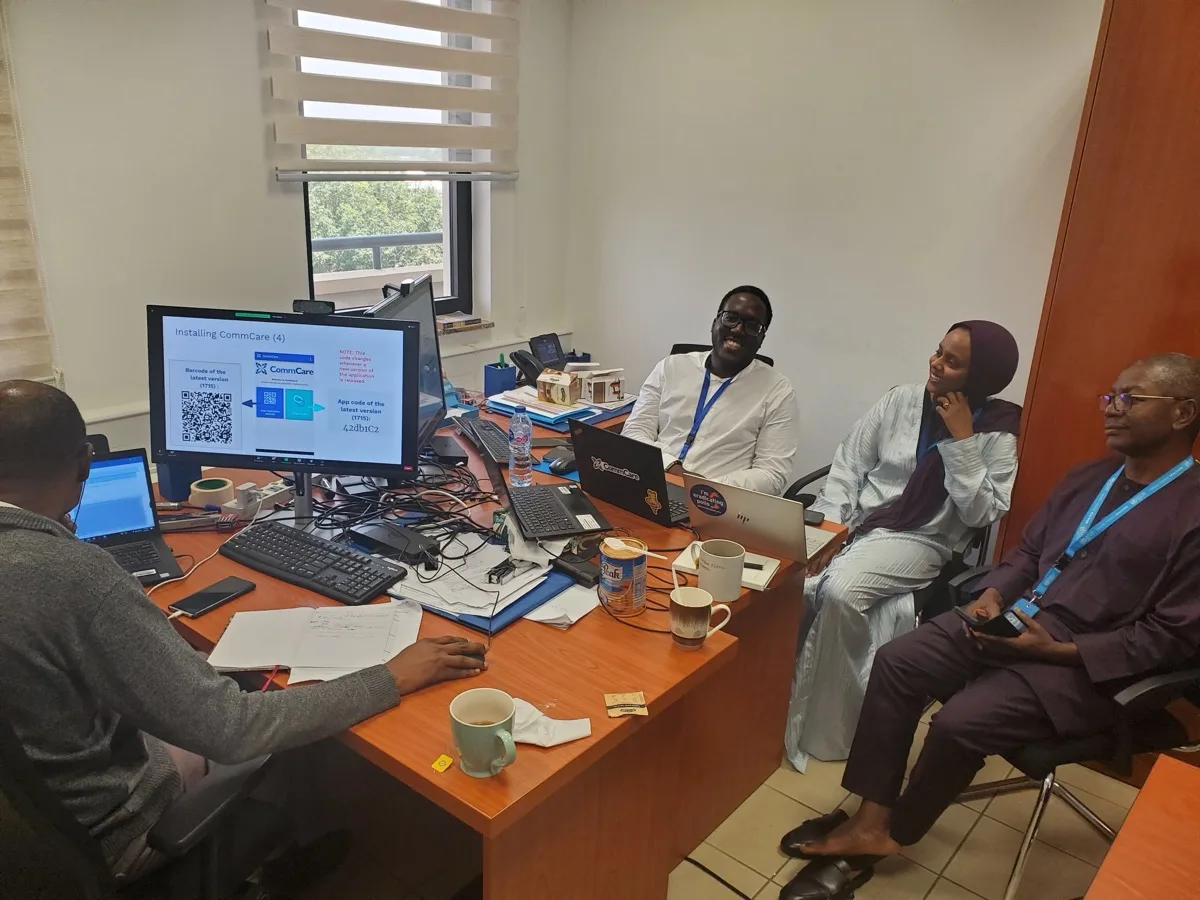 Program staff review a CommCare dashboard together in an office