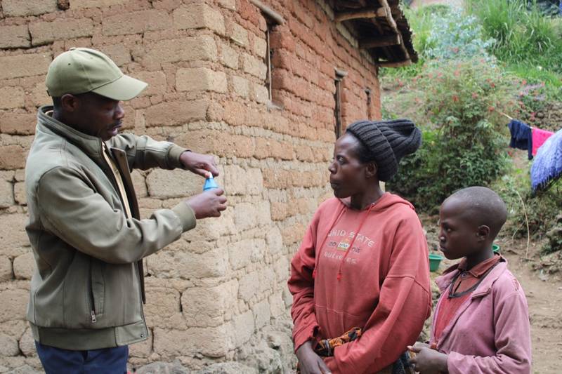 A Move Up Global community health worker demonstrating the use of Sur'Eau for water chlorination