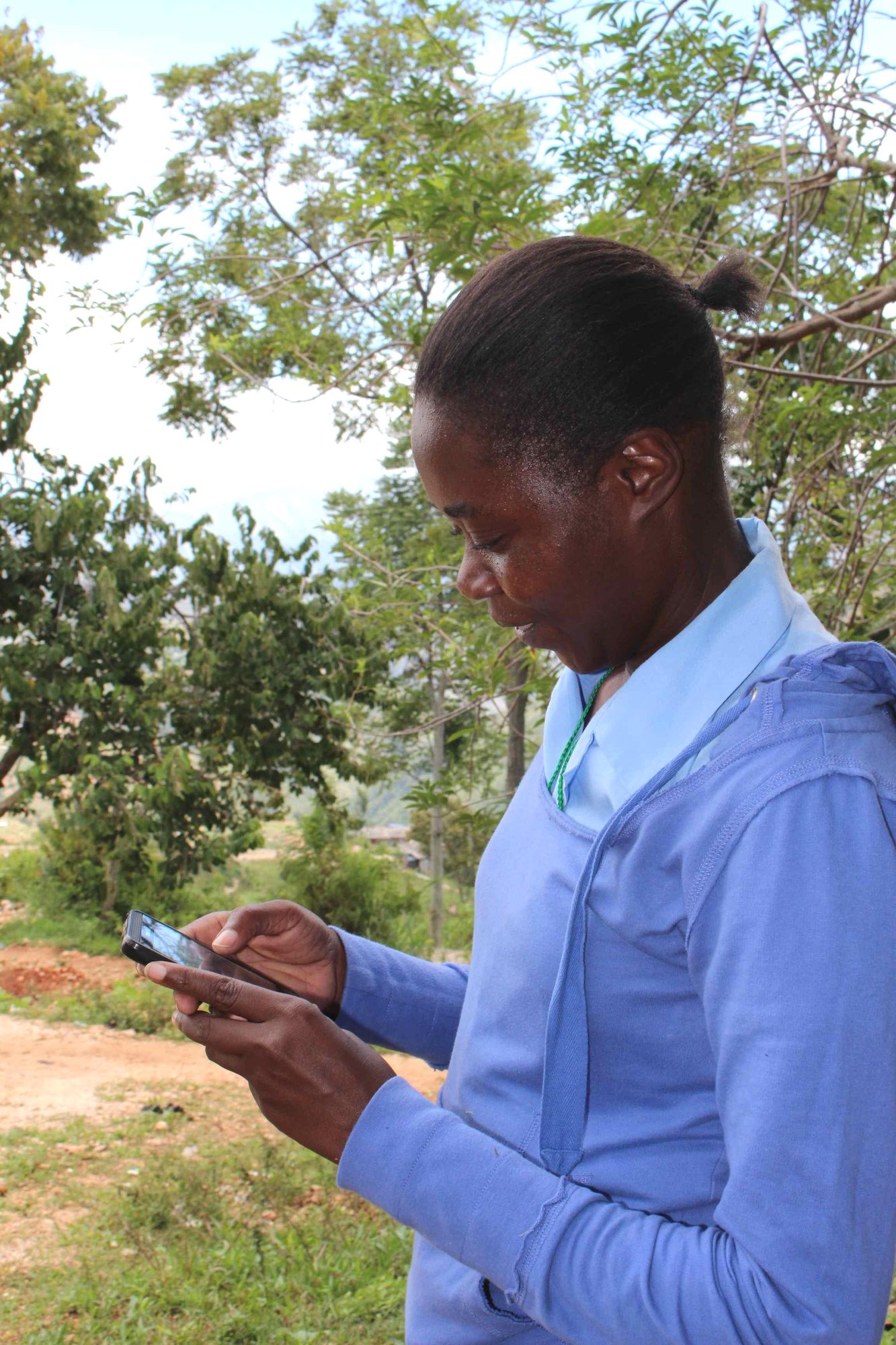 Ketcia Ovillus enters data into her handheld device between home visits