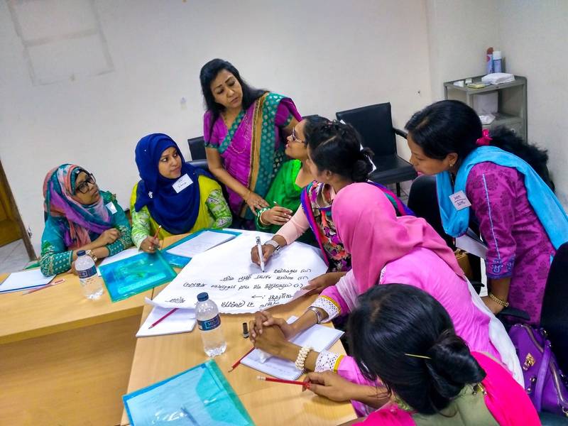 A FIGO team leads a training session for healthcare providers around a table