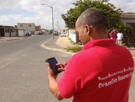 A member of the CeaseFire team using the Safety Lab's CommCare app on the streets of Hanover Park, Cape Town.