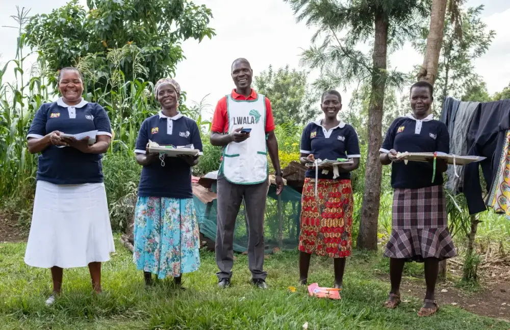 A group of community health workers standing together in the field