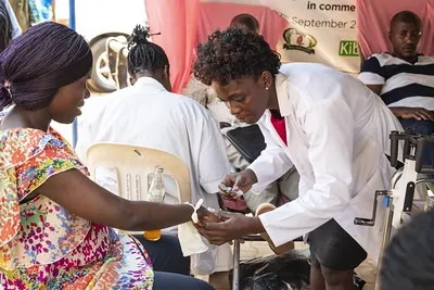 A frontline health worker screens a client at a community service point