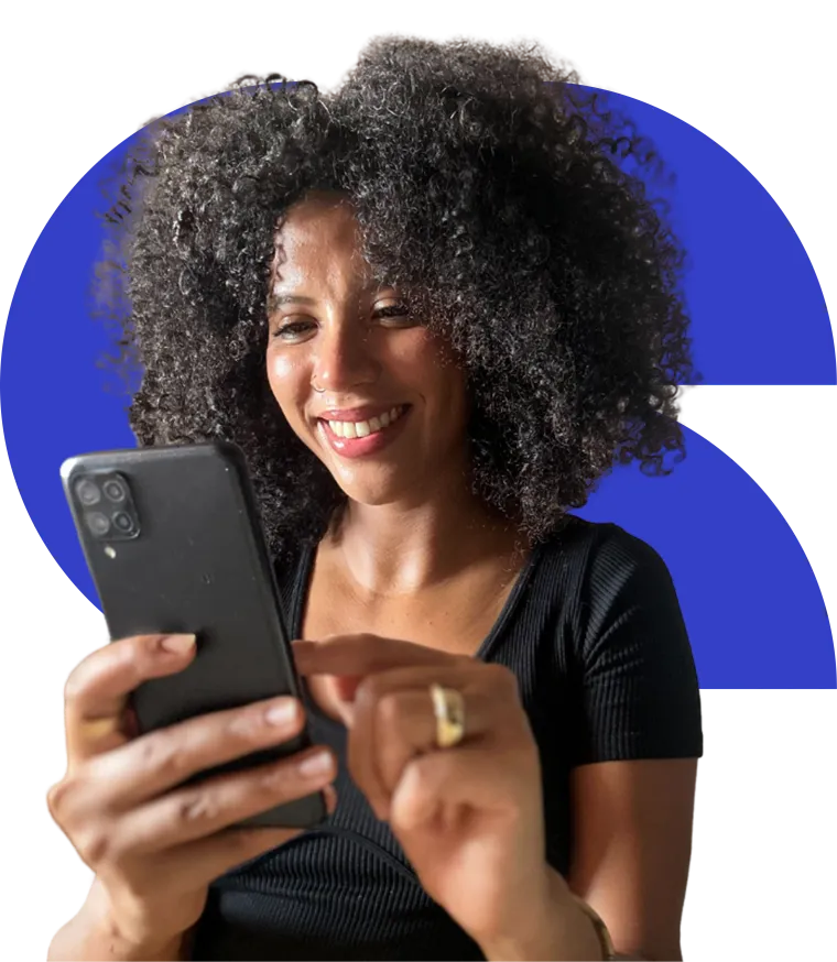 A frontline worker smiling while using CommCare on her phone.